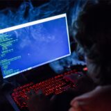 Eine Person blickt auf einen Laptop mit einer beleuchteten Tastatur.