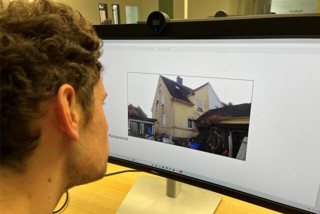 Volontär Moritz Klindworth schaut sich ein Foto von einem Haus an der Lohbuschstraße an.