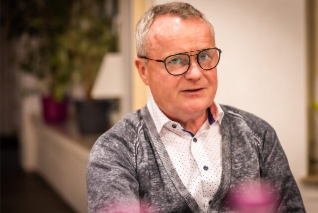 Manfred Schnieders sitzt an einem Tisch.