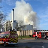 Einsatzfahrzeuge der Feuerwehr stehen vor dem Biomasse-Heizwerk in Recklinghausen-Suderwich, in dem ein Brand ausgebrochen ist.