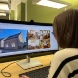 Redakteurin Julia Müller schaut sich auf dem PC-Bildschirm Fotos von einer Immobilie in Oer-Erkenschwick an.