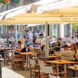 Menschen sitzen an Tischen auf dem Altstadtmarkt in Recklinghausen.