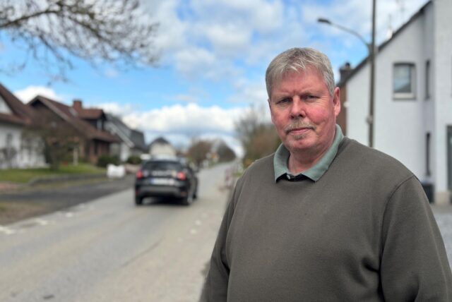 Lambertus Kramer steht vor der Beckumer Straße, hinter ihm fährt gerade ein Auto her, welches dort nicht herfahren darf.