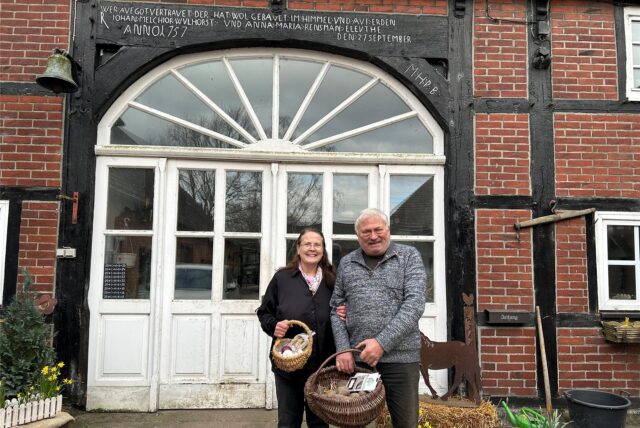 Angela und Klaus-Theo Wulhorst stehen vor dem Tor ihres Hofs in Waltrop mit Gemüsekörben in der Hand.