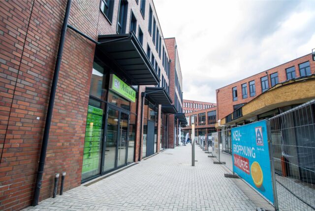 Die Zwischengasse im Baukomplex der Hertener Höfe. Noch steht ein langer Bauzaun auf der Mitte des Weges.