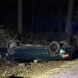 Ein grünes Auto liegt auf dem Dach auf einem Feldweg