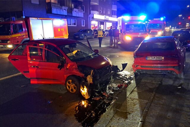 Ein schwer beschädigtes Auto, Im Hintergrund Fahrzeuge und Einsatzkräfte der Feuerwehr.