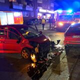 Ein schwer beschädigtes Auto, Im Hintergrund Fahrzeuge und Einsatzkräfte der Feuerwehr.