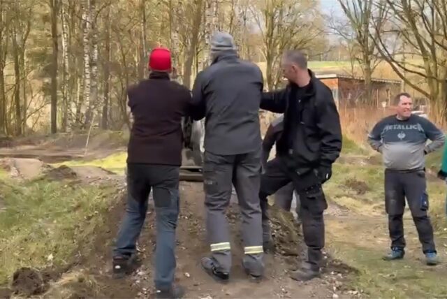 Mehrere Männer nutzen eine Planiermaschine