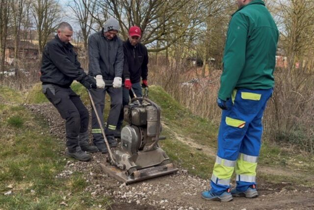 Mehrere Männer des ATV Haltern arbeiten mit einer Planiermaschine
