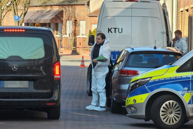 Mehrere Polizeifahrzeuge und ein Leichenwagen stehen auf der Hauptstraße in Legden.