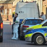 Mehrere Polizeifahrzeuge und ein Leichenwagen stehen auf der Hauptstraße in Legden.