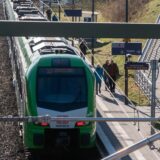 Das Bild zeigt den Haltepunkt Herten. Auf dem Gleis steht die S-Bahn der Linie S9. Mehrere Menschen laufen am Gleis entlang.
