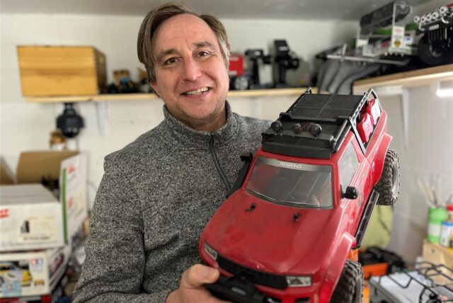 Markus Pecher hält ein rotes Modellauto in der Hand.