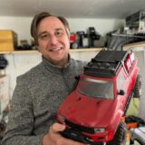 Markus Pecher hält ein rotes Modellauto in der Hand.