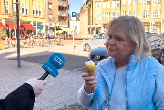 Danuta Ott isst zwei Kugeln Eis. Eine Ruhrnachrichten Reporterin hält ein Mikrofon in ihre Richtung.