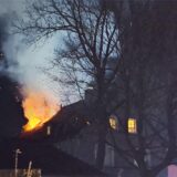 Ein Haus mit einem brennenden Dach in der Dunkelheit.