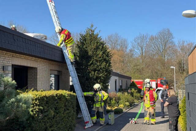 Feuerwehrleute kletterten mit Steckleitern auf das Dach eines Bungalows in Dorsten, um einen Brand zu löschen.