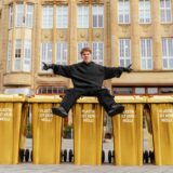 Levi Penell posiert mit goldenen Mülltonnen am Markt in Castrop.