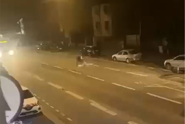 Blick auf eine Straße bei Dunkelheit. Zwei Personen sind auf der Fahrbahn. Sie sind mit einem Mosaikfilter unkenntlich gemacht.