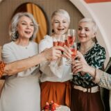 Fünf Frauen stoßen mit Sektgläsern auf den 70. Geburtstag an.