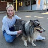 Lehrerin Alice Gisder und ihr Hund Barney sitzen auf dem Schulhof.
