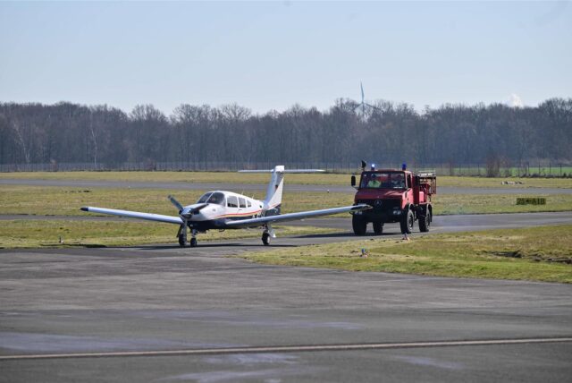 Ein Flugzeug rollt gefolgt von einem Einsatzwagen über das Rollfeld am Flugplatz Loemühle.