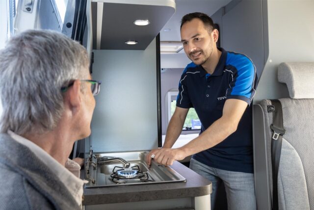 Ein Tüv-Mitarbeiter prüft in einem Wohnwagen den Gasherd.