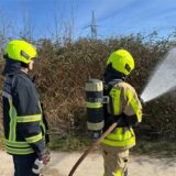 Zwei Feuerwehrleute löschen mit einem C-Schlau einen Flächenbrand.