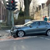 Ein Mercedes mit eingebeulter Front an einer Laterne.