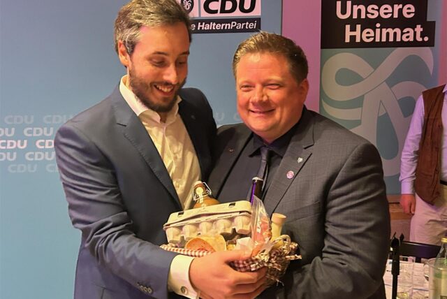 Halterns CDU-Parteichef Hendrik Griesbach überreicht dem frisch gewählten Bürgermeisterkandidaten Andreas Stegemann einen Präsentkorb mit Leckereien