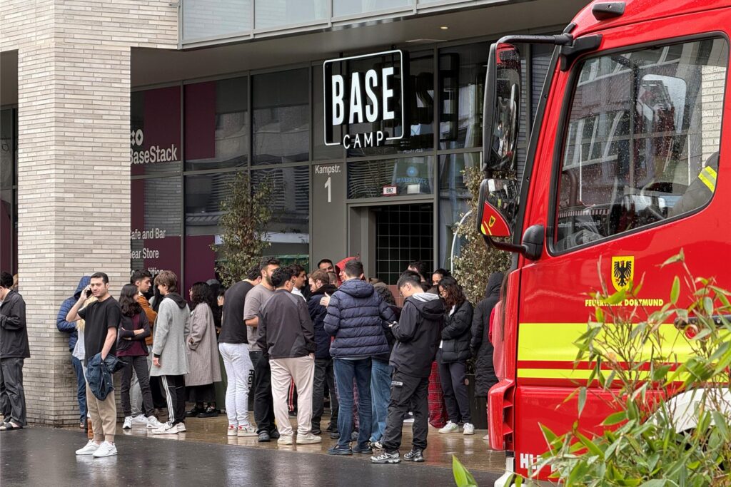 Gäste stehen während des Feuerwehreinsatzes vor dem Basecamp in der Kampstraße in Dortmund. Gäste stehen während des Feuerwehreinsatzes vor dem Basecamp in der Kampstraße in Dortmund.