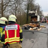 Feuerwehrleute vor einem Müllwagen.
