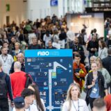 Messebesucher der FIBO laufen in Köln durch eine Messehalle.