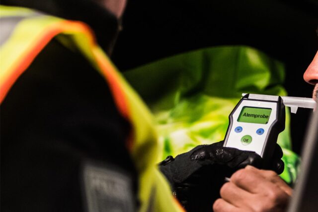 Die Polizei führt bei einem Autofahrer einen Atemalkoholtest durch