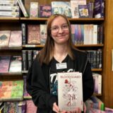 Melissa Moschny ist Auszubildende in der Buchhandlung Droste in Herten-Mitte. Sie steht vor einem Regal und hält das Buch Bloodguard in den Händen.