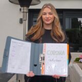 Mia Nachlik (20) steht an einen Baum gelehnt und lächelt in die Kamera.