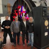 Vier Männer stehen vor einer Seilscheibe im Museum am Erzschacht in Marl.