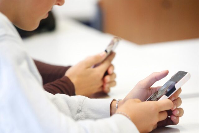 Schüler benutzen ihr Handy im Unterricht.