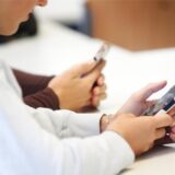 Schüler benutzen ihr Handy im Unterricht.