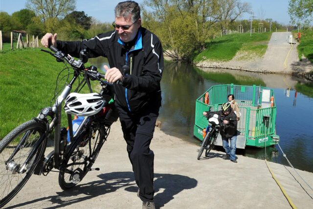 Radfahrer verlassen die Fähre Maifisch über die Lippe in Haltern