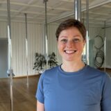Kirsten Jensen im Studio „Körpernah“. Im Hintergrund sind viele Poledance-Stangen zu sehen.