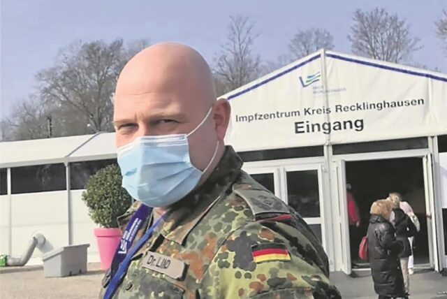 Hertens Kämmerer Dr. Oliver Lind steht in Bundeswehr-Montur vor dem Corona-Impfzentrum des Kreises Recklinghausen auf dem Konrad-Adenauer-Platz.