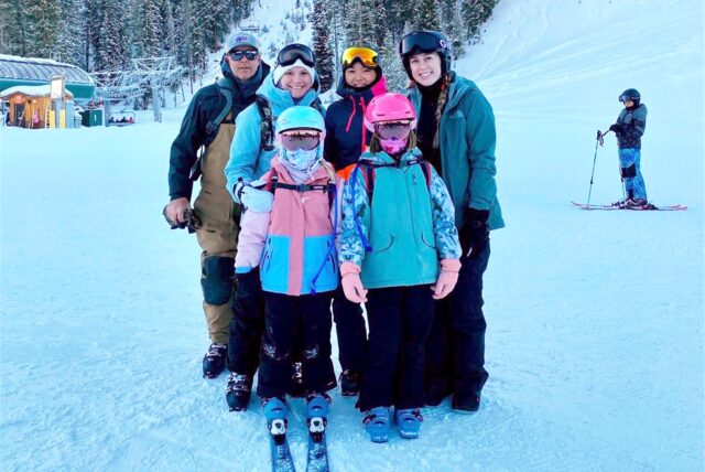 Kira Pätzold steht mit ihrer Gastfamilie in Skikleidung an einem schneebedeckten Hügel.