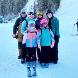 Kira Pätzold steht mit ihrer Gastfamilie in Skikleidung an einem schneebedeckten Hügel.