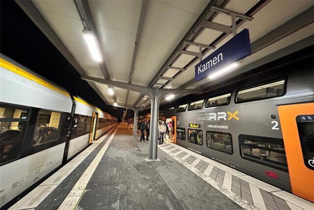 Züge stehen am Bahnhof in Kamen. Menschen steigen in eine Bahn ein.