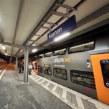 Züge stehen am Bahnhof in Kamen. Menschen steigen in eine Bahn ein.