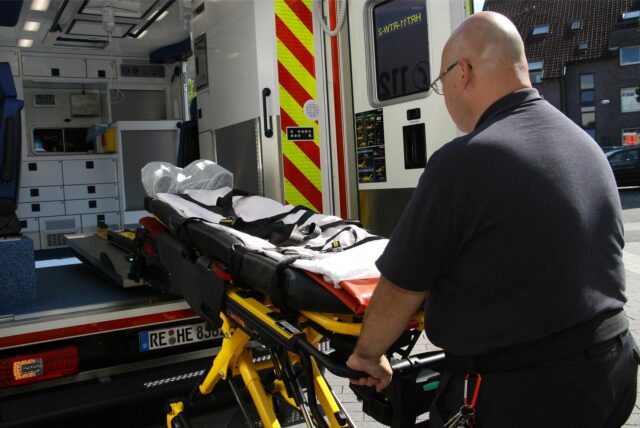 Ein Mitarbeiter des Hertener Rettungsdienstes schiebt eine Trage in einen Krankenwagen. (Symbolbild)