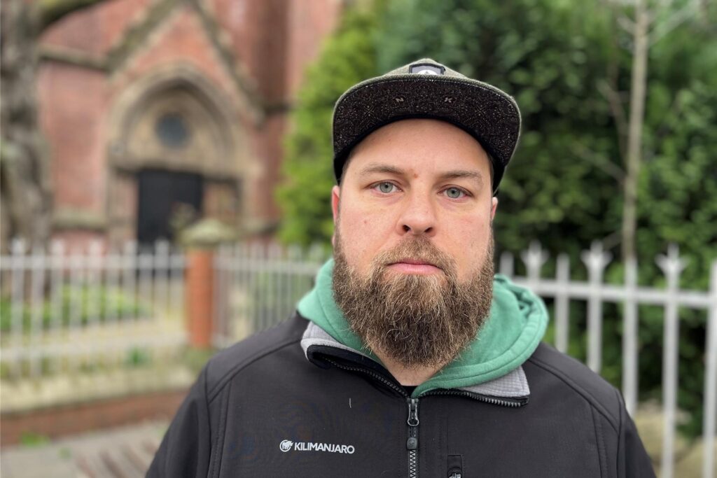 Benjamin Gottstein, Vorsitzender der Kita-Elternschaft in Dortmund, steht vor einer Kirche und schaut in die Kamera. Benjamin Gottstein, Vorsitzender der Kita-Elternschaft in Dortmund, steht vor einer Kirche und schaut in die Kamera.