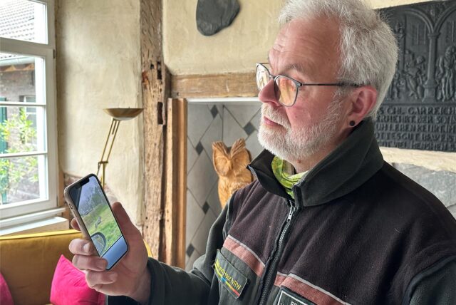 Wolfsberater Winfried Hardes schaut sich das Video mit dem vermeintlichen Wolf aus dem Dortmunder Süden auf dem Handy an.